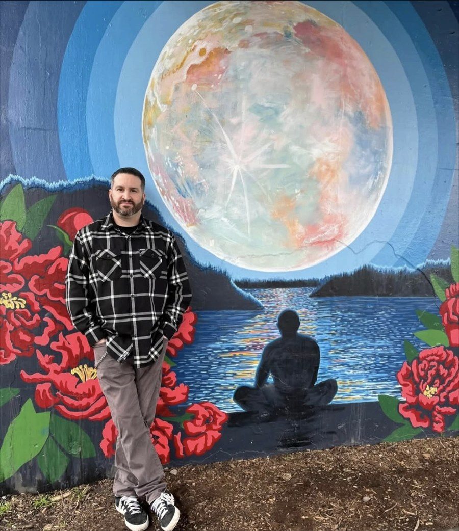 Joe Conniff in front of a meditation mural