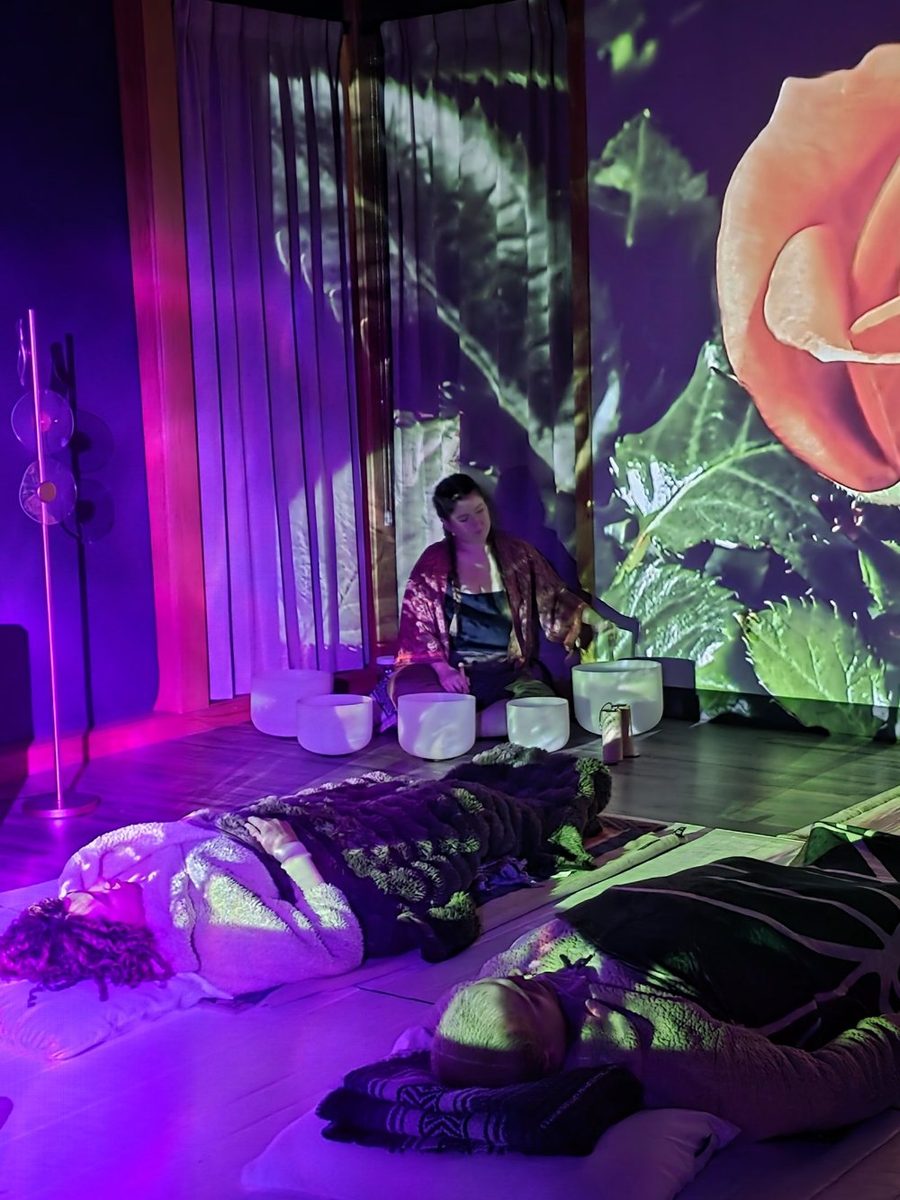 Julia Nathe playing crystal bowls during a sound bath at Origin Minds